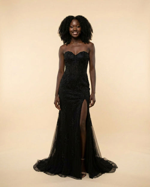 Robe de bal noire ajustée à décolleté cœur, bretelles fines et fente haute sur la jambe.