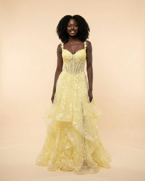 Robe de bal à corset de dentelle florale et jupe de tulle à étages froncés, présentée sur mannequin en boutique.