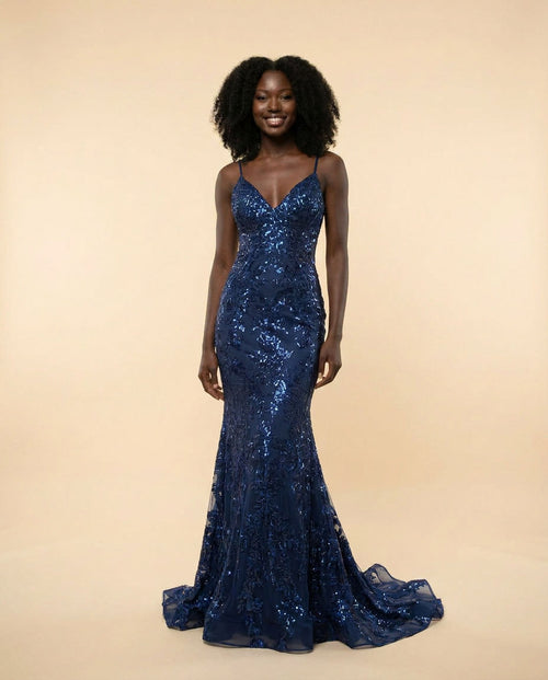 Femme portant une robe sirène bleu marine à paillettes florales, décolleté en V et fines bretelles, avec longue traîne.