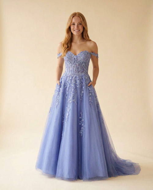 Robe de bal bleu bleuet à décolleté cœur, bustier corset transparent en dentelle florale et jupe de tulle ample.