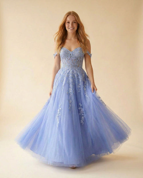 Robe de bal princesse bleu pervenche à corset transparent, décolleté cœur, appliqués floraux et jupe de tulle pailletée, vue de face.