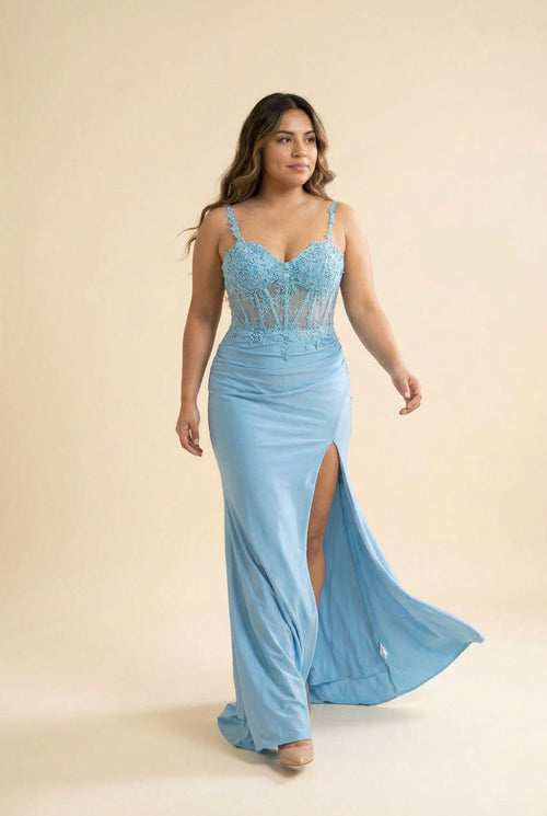 Femme portant une robe sirène bleu désert à bustier corset en dentelle transparente et fente haute, devant une porte et des rosiers.