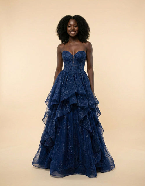 Robe de bal marine à bustier corset en dentelle, décolleté cœur et jupe de tulle scintillant à étages froncés, vue de face.
