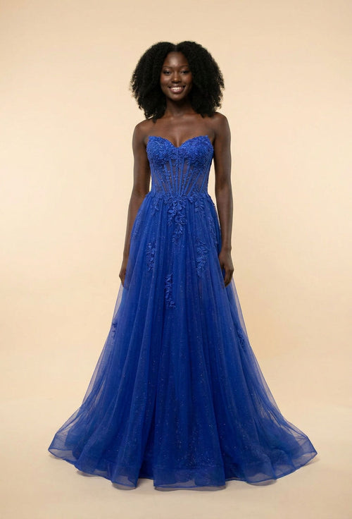Femme portant une robe de bal bleu royal, bustier corset au décolleté cœur et ample jupe de tulle à appliqués floraux.