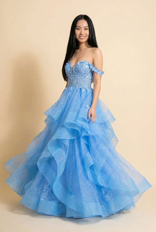 Femme portant une robe de bal bleu clochette à bustier de dentelle florale et jupe de tulle scintillant en étages froncés.