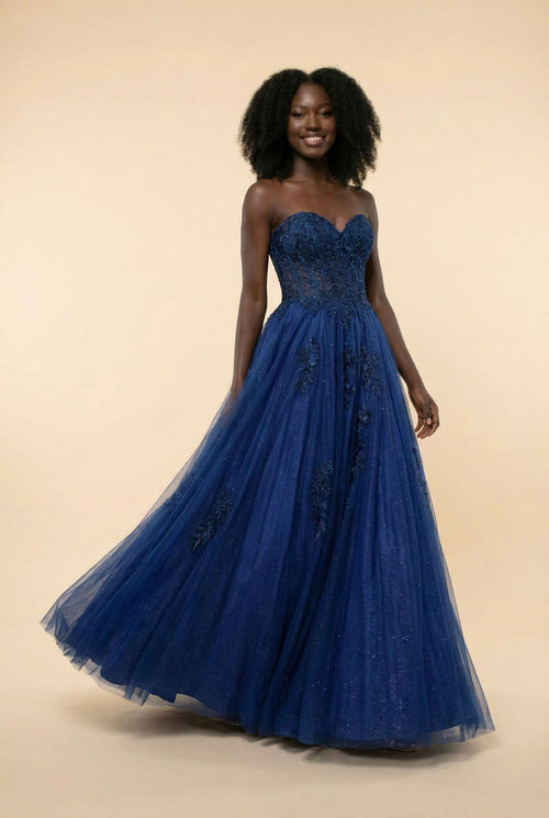 Robe de bal princesse bleu marine à bustier de dentelle florale, décolleté en cœur et jupe de tulle scintillante, vue de devant.