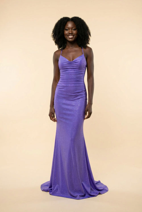Robe de bal sirène violet à décolleté cœur et fines bretelles, tissu chatoyant avec traîne, portée devant des parois rocheuses.