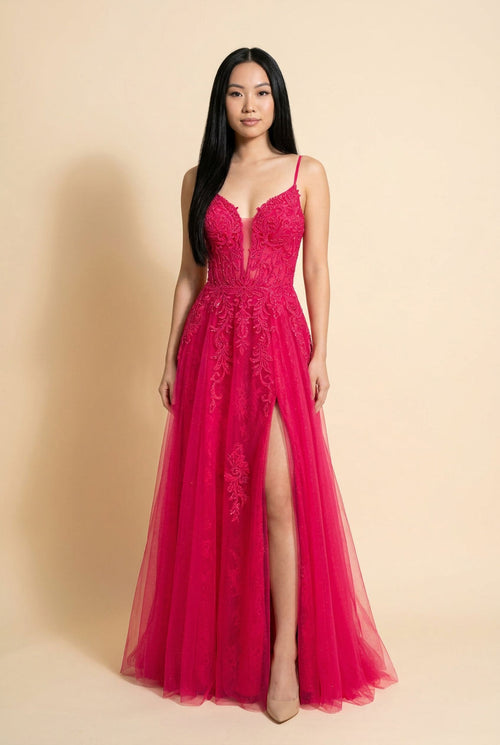 Femme portant une robe de bal rose bonbon à corsage de dentelle brodée, décolleté cœur et jupe de tulle évasée avec fente à l'avant.