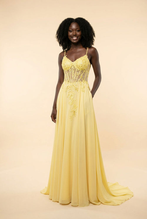 Robe de bal jaune pâle au bustier corset transparent en dentelle florale perlée, bretelles fines et jupe de mousseline évasée avec traîne.
