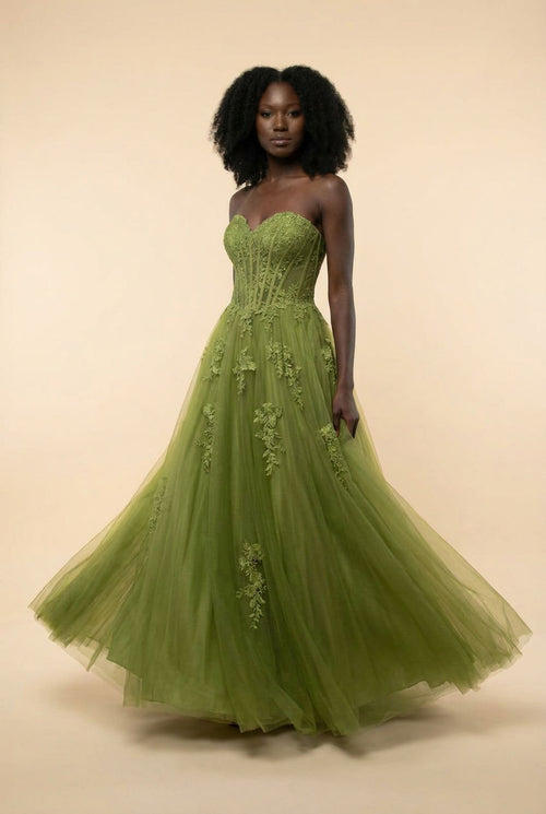 Femme portant une robe de bal corset à encolure en cœur avec jupe princesse en tulle vaporeuse ornée d'appliqués floraux.