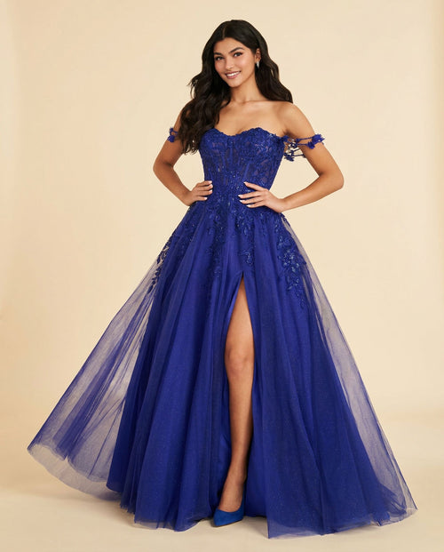 Femme portant une robe de bal bleu royal à bustier de dentelle florale, décolleté cœur, bretelles tombantes et jupe de tulle à fente haute.