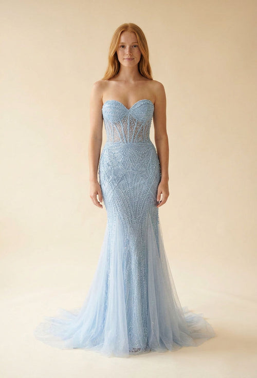 Femme portant une robe de bal sirène bleu pâle à bustier perlé transparent et décolleté en cœur, jupe de tulle scintillant.