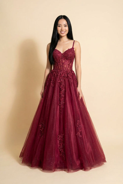 Robe de bal à corset de dentelle florale avec décolleté en cœur et jupe de tulle scintillant, présentée devant des falaises rouges.
