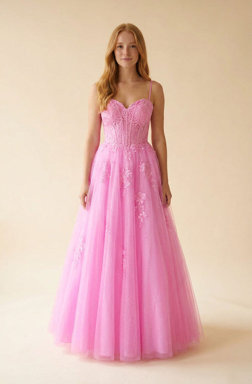Robe de bal rose vif à corset baleiné, décolleté cœur et jupe de tulle princesse aux appliqués floraux.